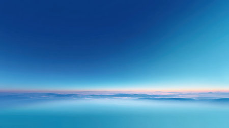 A breathtaking view of a serene horizon featuring a soft blue gradient sky above calm ocean waters, illuminated by the gentle hues of dawn, creating a tranquil scene.の素材