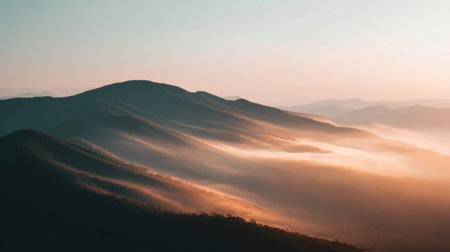Captivating view of rolling hills gently shrouded in mist during sunrise, showcasing a serene and tranquil landscape that invites exploration and appreciation of nature's beauty.の素材