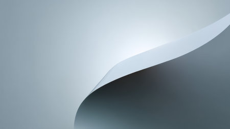 This image features a sleek curl of white paper against a soft gray background, illuminated by a subtle light reflection. Ideal for clean and modern design projects.の素材