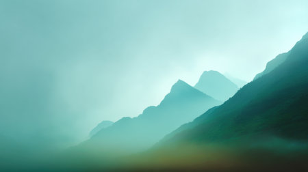 This stunning mountain landscape captures the serene beauty of nature with soft fog enveloping the peaks, creating a tranquil atmosphere perfect for relaxation and inspiration.の素材