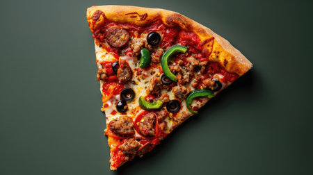 Deep-dish pizza slice with sausage, green peppers, and black olives, top viewの素材