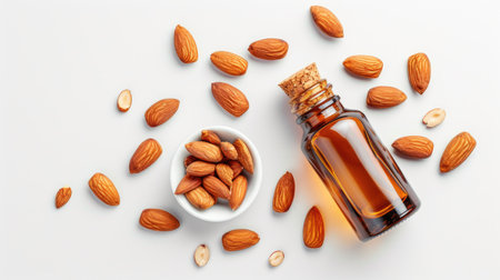Almond oil bottle and nuts arrangement, isolated on white, top viewの素材