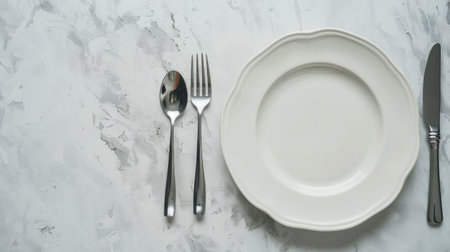 Stylish setting with minimalistic silverware and plate on light textured tabletop, top view.の素材