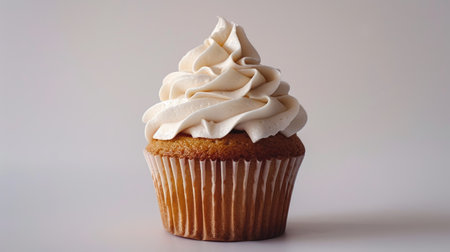 Delicious vanilla cupcake with whipped cream frosting on whiteの素材