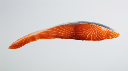 Raw salmon in free fall against a white backdrop, showcasing its bright pink hue and smooth texture, full depth of fieldの素材