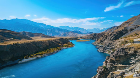 Majestic blue water river winding through rugged terrain, captured on a sunny day with clear blue skyの素材