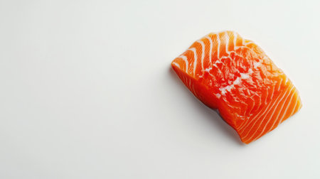 Top-down view of a slice of bright red salmon on a clean white background, perfect for food-related imagery with ample space for text or designの素材