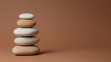 Podium made of stacked pebbles on a brown background, perfect for product displays with clear space for promotional text.の素材