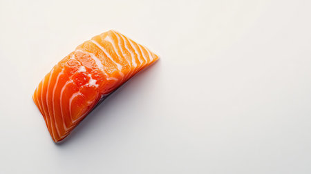 Top-down view of a slice of bright red salmon on a clean white background, perfect for food-related imagery with ample space for text or designの素材
