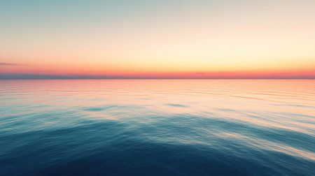 A calm sea reflecting the colors of a vibrant sunset, with the horizon stretching endlessly into the distance.の素材
