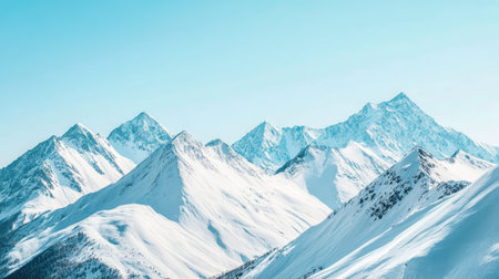 Snow-covered mountain peaks under a clear blue sky, representing the pristine beauty of untouched natureの素材