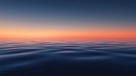 A calm sea at dusk, with the sky transitioning from blue to deep orange and the water reflecting the colors.の素材