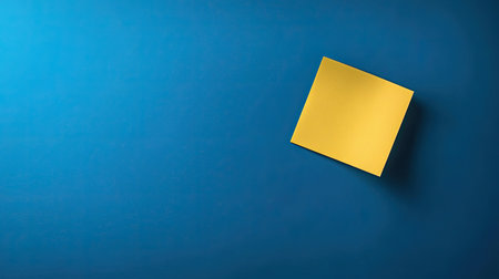 Minimalist blue background with a single yellow sticky note, placed diagonally and slightly curledの素材