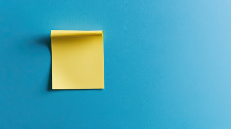 Minimalist blue background featuring a single yellow sticky note, perfectly placed and slightly curledの素材