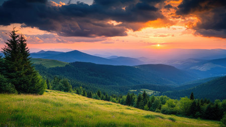 Breathtaking view of a mountain landscape with rolling hills, forests, and a dramatic sunset skyの素材