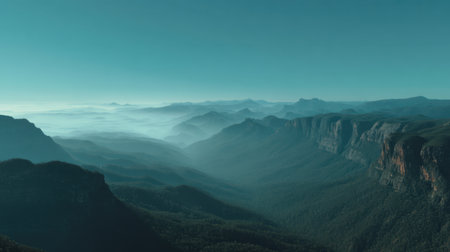 This stunning landscape captures the essence of nature's beauty, featuring layered mountains, soft mist in the valleys, and a tranquil blue sky that inspires exploration.の素材