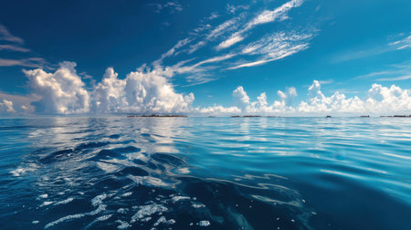A serene ocean view showcasing deep blue water under a bright sky adorned with fluffy white clouds. Perfect for relaxation and escape to nature's tranquility.の素材