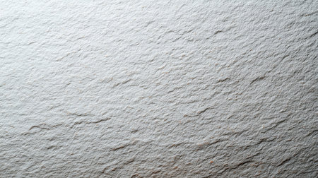This image features a textured gray paper surface with subtle highlights and shadows, perfect for use in artistic designs, backgrounds, or creative projects.の素材