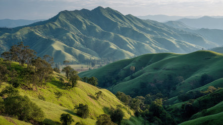Lush green hills create a stunning landscape under a clear sky, showcasing a serene environment perfect for outdoor adventures and nature photography.の素材