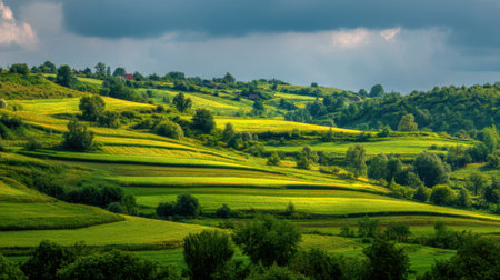Stunning view of rolling hills blanketed in vibrant green fields under a dramatic sky. This serene landscape captures the beauty of nature and tranquility.の素材