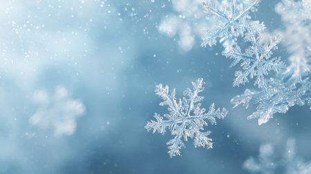 Discover the beauty of winter with this stunning close-up of snowflakes falling gently against a soft blue background, capturing the serene essence of the season.の素材