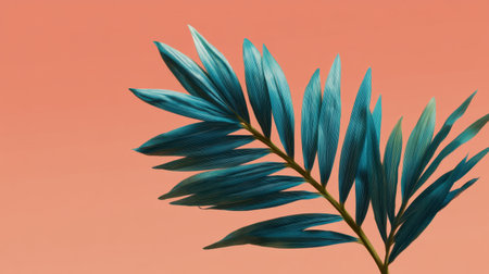 A vivid blue palm leaf contrasts beautifully with a soft coral background, creating an eye-catching tropical scene. Perfect for nature-focused projects and decor.の素材