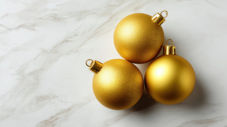 Three beautifully crafted gold Christmas ornaments resting gracefully on a marble background, perfect for inspiring festive decoration and holiday cheer.の素材