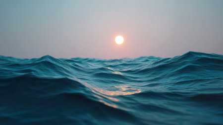 A tranquil scene featuring gentle ocean waves under a serene evening sky, with a glowing sun setting on the horizon, creating a peaceful and reflective atmosphere.の素材