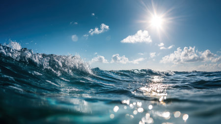 Discover the beauty of nature with this stunning view of ocean waves under a bright blue sky. Sun rays glisten on the water, creating a serene and tranquil scene.の素材