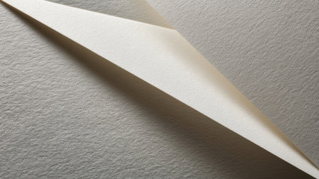 Close-up view of textured paper folded elegantly to create depth and shadows, showcasing a minimalist design aesthetic under natural light. Perfect for art and design projects.の素材