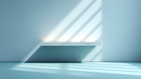 A sleek, minimalist shelf rests against a soft blue wall, illuminated by gentle shadows created by natural light, ideal for tranquil interior design settings.の素材