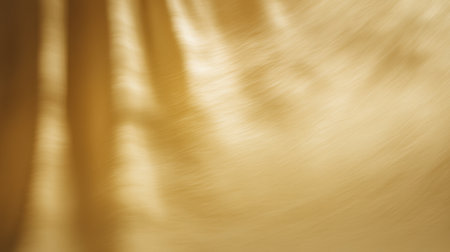 This image showcases a smooth golden fabric with a soft focus, creating an elegant and warm background suitable for themes related to luxury and style.の素材