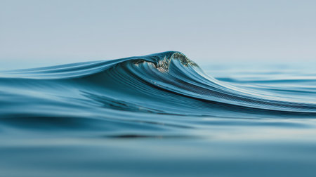 A stunning close-up of a gentle ocean wave captured in soft light, showcasing the serene beauty of water, reflecting tranquility and peaceful nature during early morning.の素材