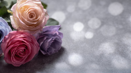 A stunning close-up of a pink, purple, and blue rose arrangement set against a soft grey background with a gentle bokeh effect, perfect for capturing beauty and elegance.の素材