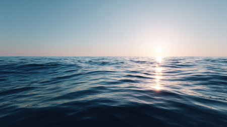 Tranquil view of the ocean at sunrise, showcasing gentle waves and a soft light reflected in the water, perfect for calming backgrounds or nature themes.の素材
