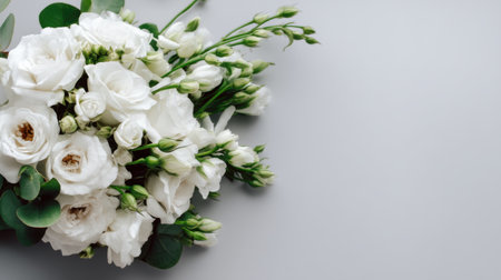 Charming arrangement of white flowers and delicate greenery on a soft gray background. Ideal for wedding planning, events, or floral design inspiration.の素材