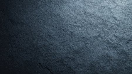 A dark natural stone surface featuring rich textures and subtle shadows, ideal for use as a background in design projects or artistic presentations.の素材