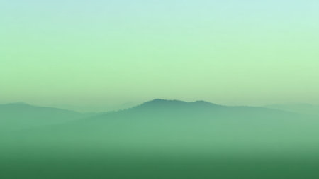 A tranquil landscape featuring layered mountains enveloped in soft green hues and mist, creating a serene atmosphere perfect for relaxation and reflection.の素材