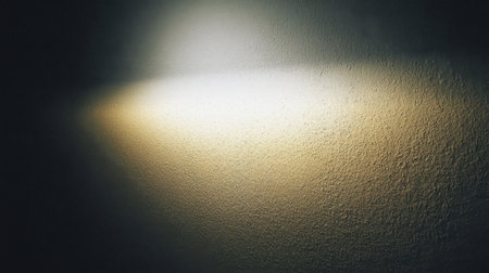 A beautifully lit wall displaying textures with a soft gradient of light and shadow creates a warm yet cool atmosphere, perfect for artistic ambiance and decor.の素材