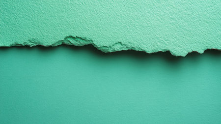 A close-up view of textured green paper with a torn edge, presenting an interesting interplay of layers and colors, perfect for use in design and artistic projects.の素材