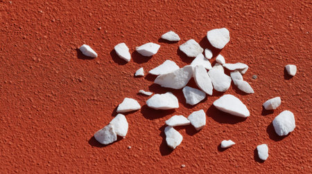 A captivating close-up image showcasing small white rocks scattered on a textured red surface, highlighting the natural beauty and striking color contrast.の素材