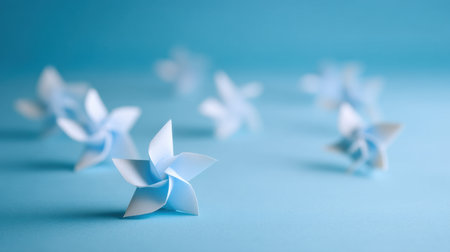 This image showcases delicate blue paper flowers arranged on a light blue surface, creating a serene and creative atmosphere perfect for artistic projects and decorative inspiration.の素材