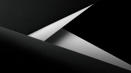An abstract representation of black and white paper arranged in geometric shapes, highlighting the interplay of light and shadows with unique textures and angles.の素材