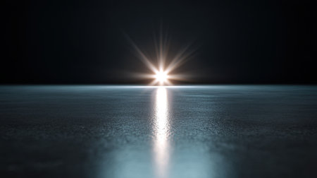A mesmerizing light shines on a smooth surface, creating an ethereal atmosphere in a dark environment. The reflection and subtle shadows enhance the captivating scene.の素材