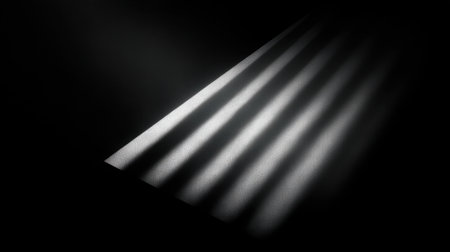 A captivating visual of light breaking through horizontal lines in a dark space, creating striking patterns of shadows and illumination that evoke minimalism and contrast.の素材