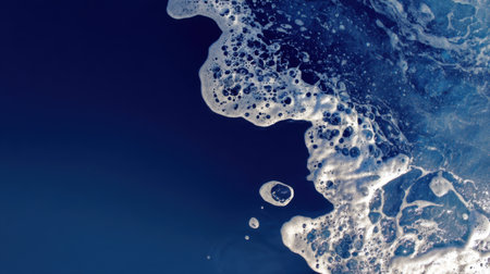Captivating ocean wave foam texture with bubble formations against a deep blue backdrop. Perfect for showcasing nature's beauty and aquatic themes.の素材