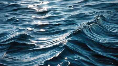 A captivating view of deep blue ocean waves glistening under bright sunlight. This serene image captures the beauty and tranquility of nature's water surface.の素材
