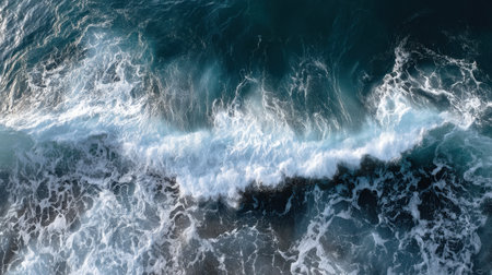 Experience the mesmerizing beauty of ocean waves from above, showcasing dynamic patterns of water and foam as they crash along a rugged shoreline.の素材