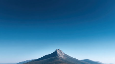 The image features a striking mountain peak rising under a bright blue sky, showcasing the vast natural landscape and serene beauty of the surrounding environment.の素材