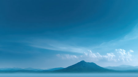 A breathtaking view of a serene mountain with a clear blue sky and fluffy clouds. Perfect for showcasing tranquility and natural beauty in outdoor settings.の素材